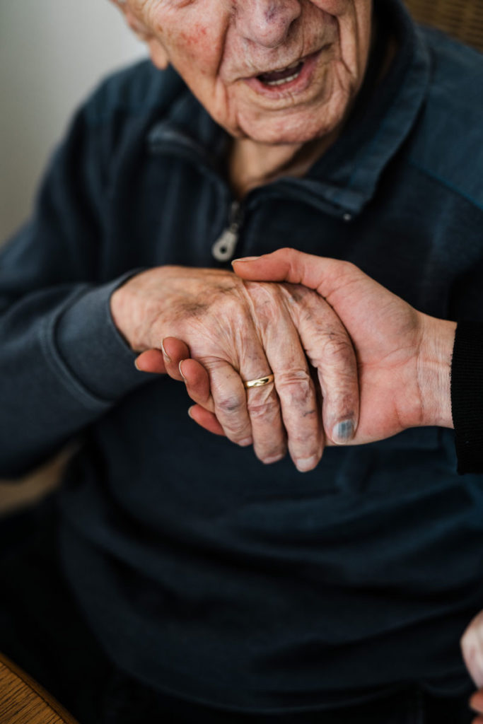 sanamed Pflegeteam, Pflegerin gibt einem Senior die Hand, Pflegedienst Havixbeck